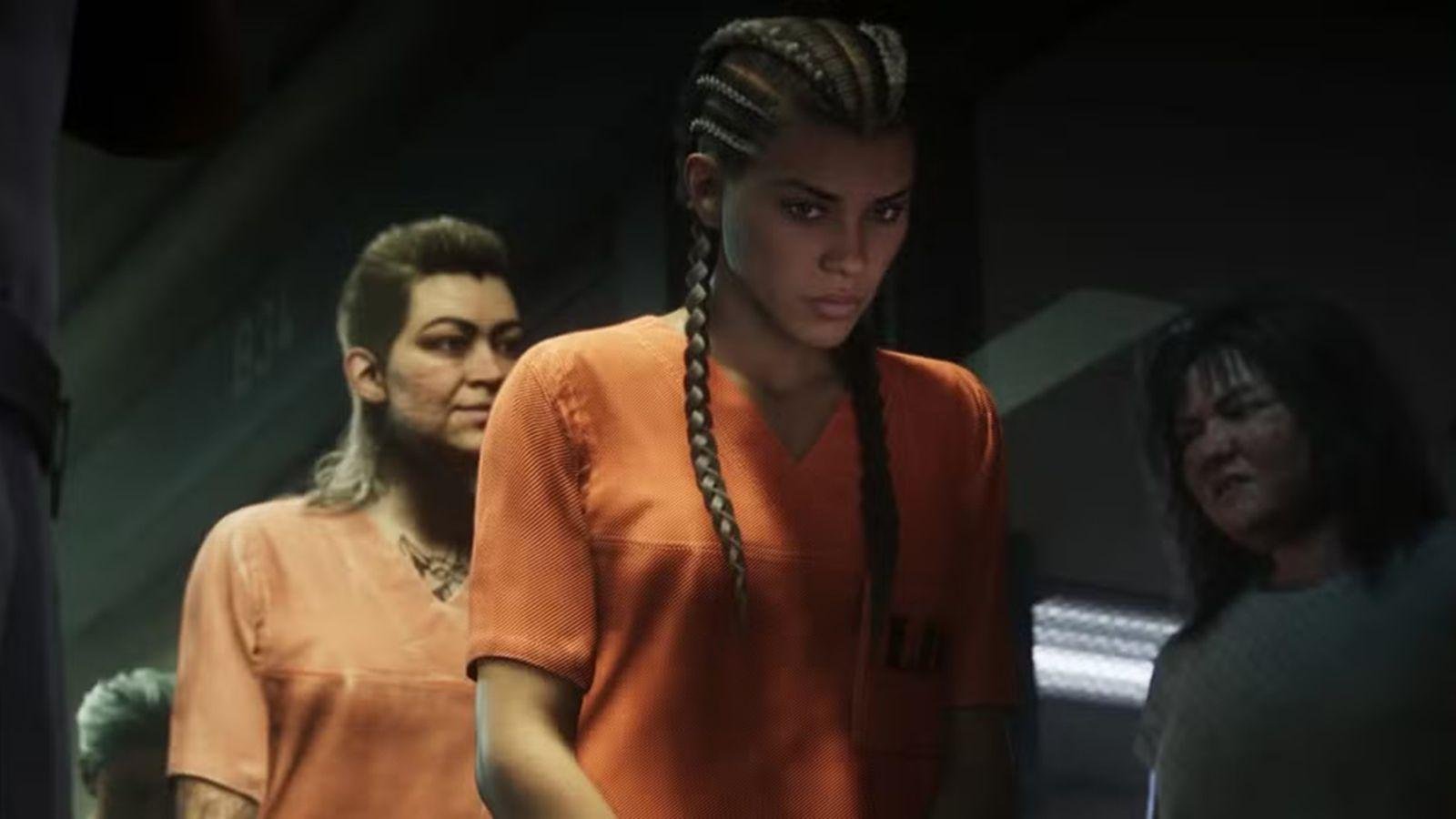 Official GTA VI screenshot: Lucia in an orange prison jumpsuit, standing among other inmates in a dim prison corridor